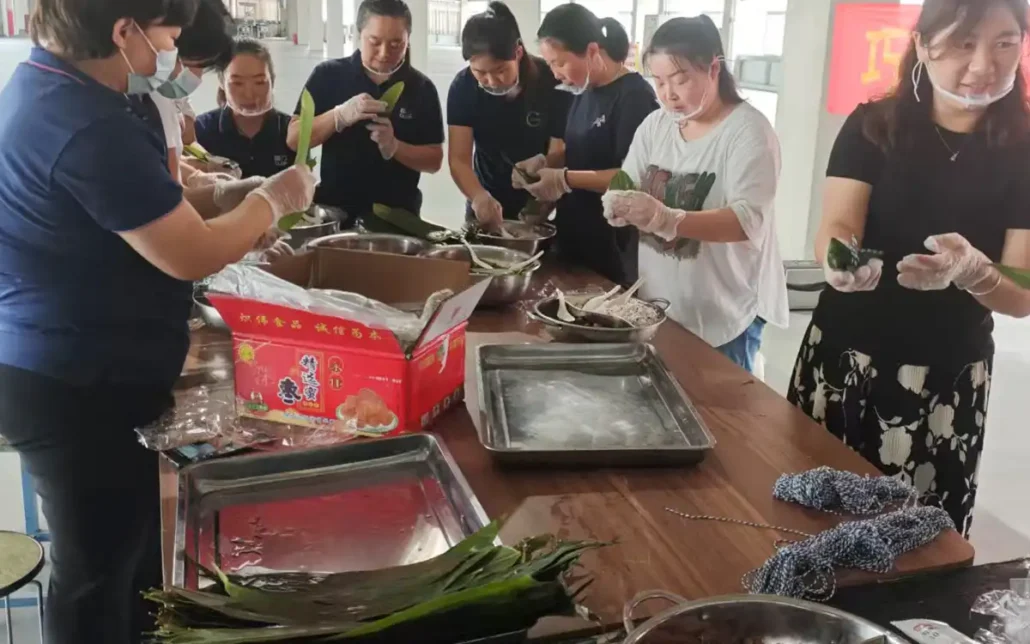 Colleagues wearing disposable gloves and food masks are making Zongzi